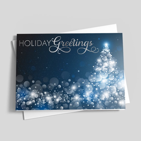 Folded holiday card with dark blue background and white bokeh light tree