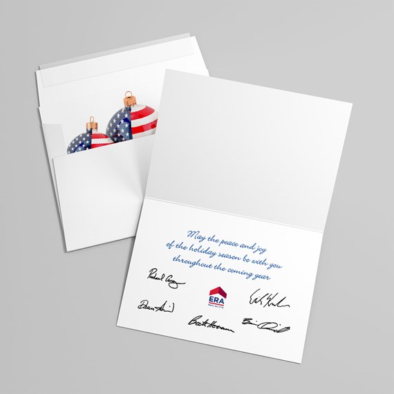 folded holiday greeting card with blue cursive message, signatures, and American-flag Christmas ornaments in an envelope