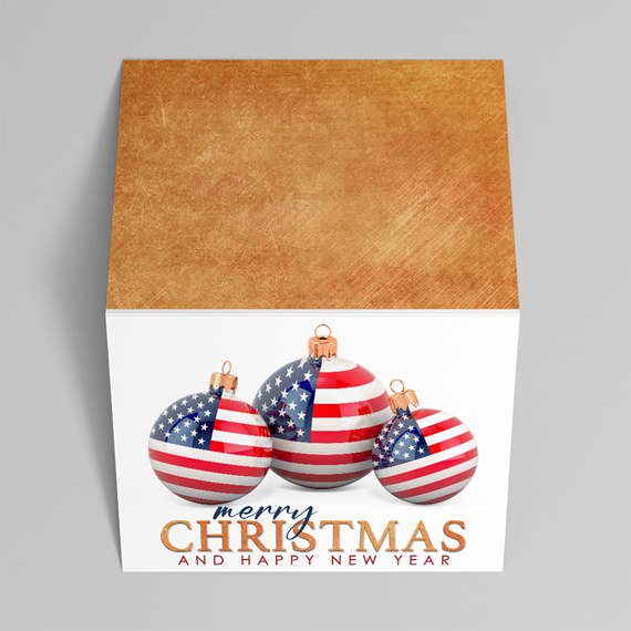 Square gift box with gold lid and American-flag Christmas ornament baubles on white front