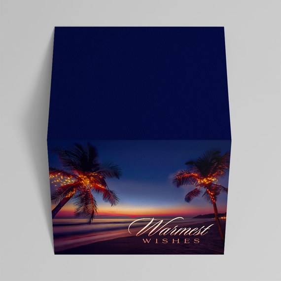 Square gift box with navy lid, tropical beach sunset side art, palm trees with string lights and 'Warmest Wishes' greeting