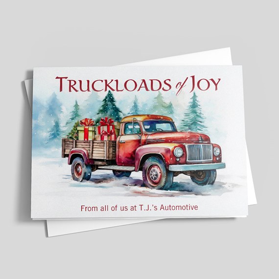 Watercolor holiday card showing a red vintage pickup truck carrying wrapped gifts in snow with pine trees