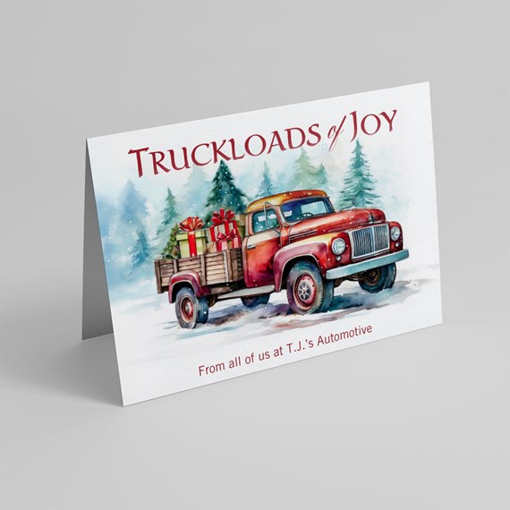 Folded holiday card featuring a watercolor red pickup truck loaded with gifts and a Christmas tree in a snowy forest.