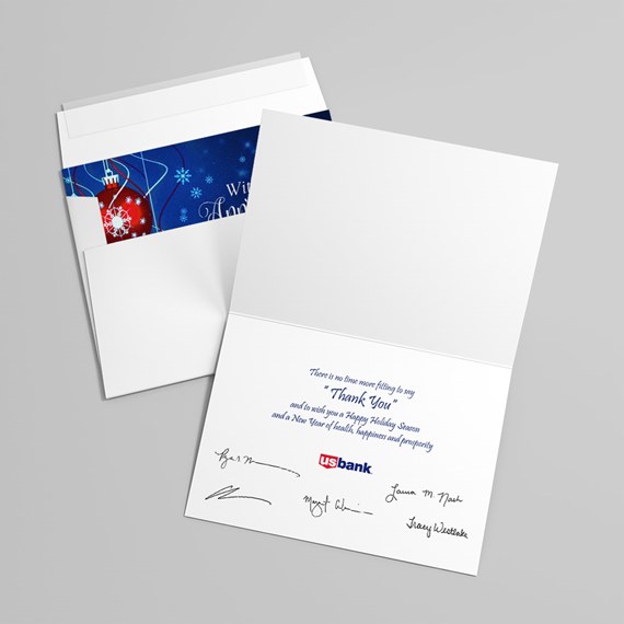 Folded white greeting card with matching envelope and blue holiday liner, open to show printed interior message