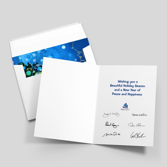folded holiday greeting card with blue printed message and signatures, shown with white envelope featuring a blue patterned liner
