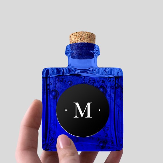 blue glass bottle with cork and black label