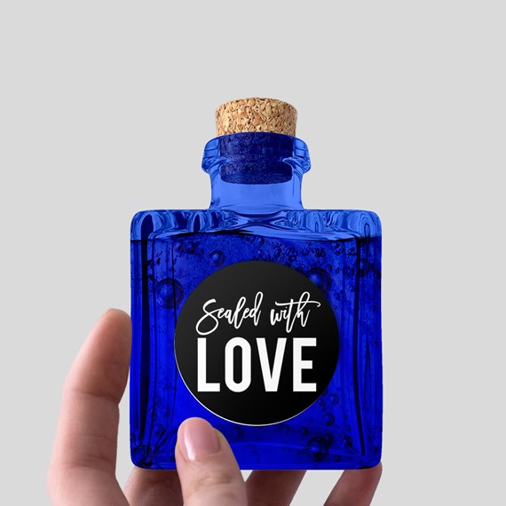 blue glass bottle with cork and black label