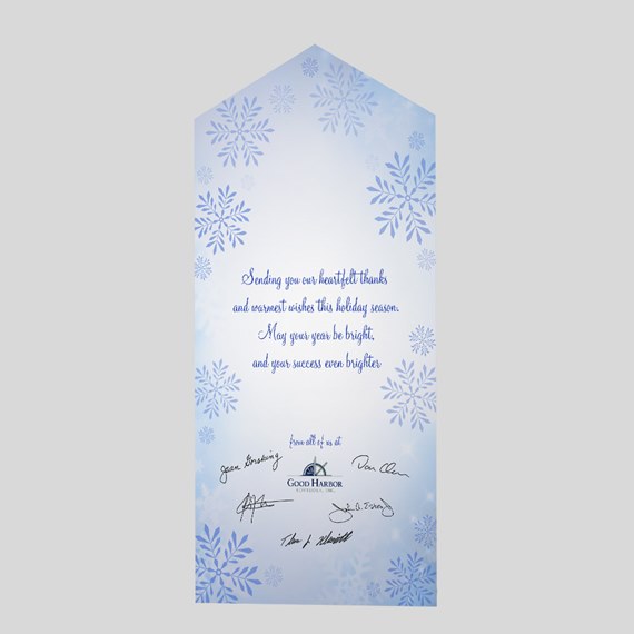 Die-cut holiday gift tag with blue snowflakes, light blue gradient background, cursive seasonal message and signatures